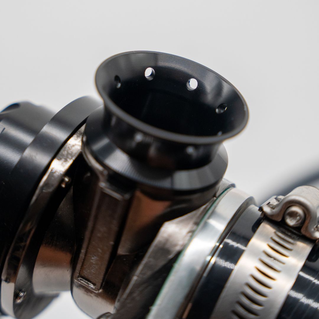 Close-up of a metallic and black mechanical component on a light gray background